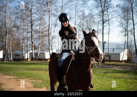 Ritratto di Femminile Jockey sicuro con Cavallo in piedi sul campo Foto Stock