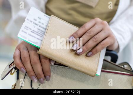 Closeup femminile tourist documenti di controllo mani, passaporto e biglietto ottenere pronto imbarco in aeroporto Foto Stock