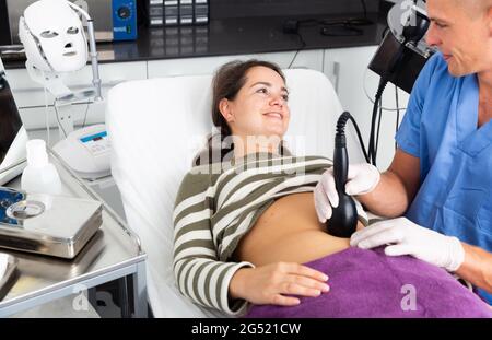 Donna che ottiene ecografia procedura per il contorno del corpo Foto Stock