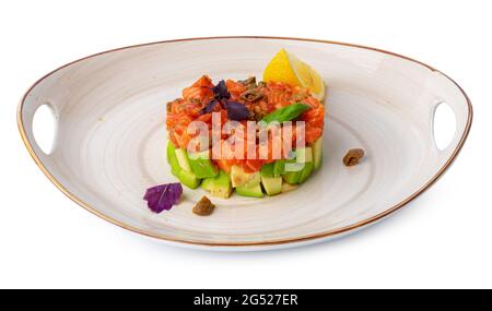 Tartare di salmone con avocado su piastra isolata su bianco Foto Stock