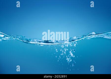 Onde d'acqua, acqua spruzzata onda in acqua blu pulita. Foto Stock