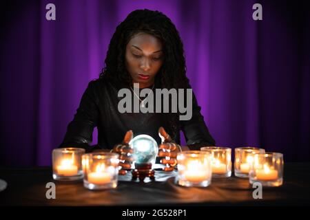 Fortune Teller che prevede il futuro utilizzando Crystal Ball Foto Stock