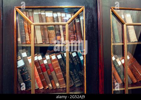 Biblioteca con libri antichi . Libri antichi nella credenza Foto Stock