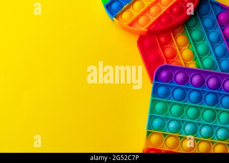 Colorato antistress pop it giocattolo su sfondo giallo Foto Stock