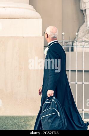 Sacerdote con maschera protettiva che va alla chiesa per celebrare la messa durante la seconda emergenza di Covid o Coronavirus, verticale Foto Stock