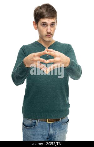 Giovane bell'uomo bianco sottile e alto con capelli marroni con dita unite in pullover verde scuro in jeans blu isolati su sfondo bianco Foto Stock