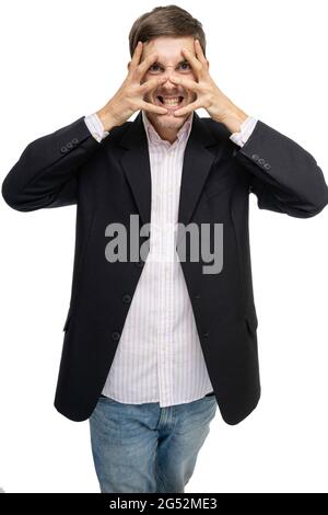 Giovane bell'uomo bianco alto e sottile con capelli marroni che fa il viso pazzo in nero blazer isolato su sfondo bianco Foto Stock
