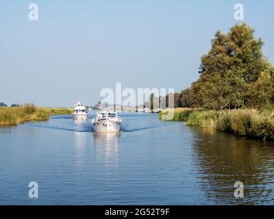 Barche a motore che navigano sul canale nel parco nazionale Alde Feanen, Frisland, Paesi Bassi Foto Stock