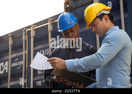 ingegnere professionale e uomo d'affari che controlla e ispeziona i contenitori nel carico internazionale al porto logistico. industriale, trasporto, wareho Foto Stock