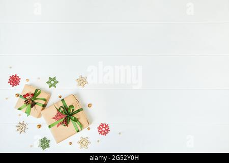 Due confezioni regalo avvolte in carta kraft su sfondo di legno bianco Foto Stock