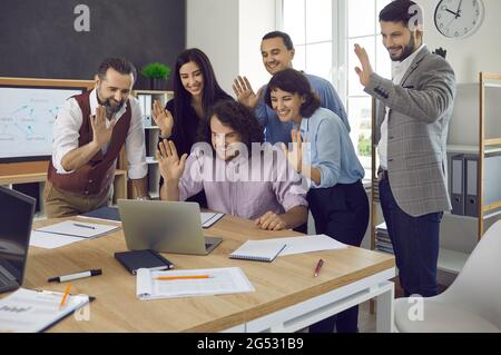 Il team dei colleghi d'affari è lieto di salutare mentre si ha una riunione online tramite un computer portatile Foto Stock