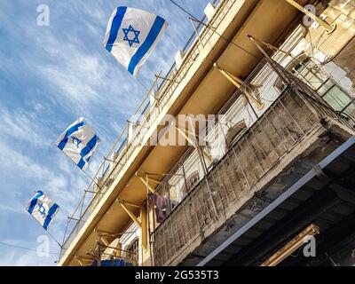 Bandiere israeliane sul vento e il cielo blu nella vecchia città di Gerusalemme Foto Stock