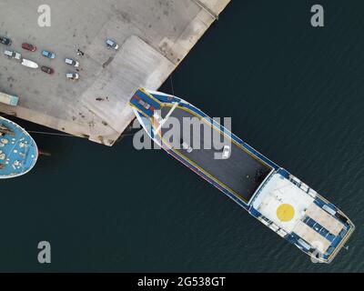 Auto con vista aerea camion in attesa di essere caricati in navi traghetto al molo nel porto di igoumenitsa città per viaggiare sull'isola di corfù in grecia Foto Stock