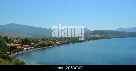 Molyvos, Lesvos, Grecia Alberghi, ristoranti e spiaggia con montagne sullo sfondo. Foto Stock