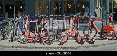 Moto elettriche e scooter noleggiabili parcheggiati nella strada del centro di Cambridge Foto Stock