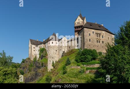 Il castello medievale su un promontorio roccioso, circondato su tre lati dal fiume Ohře, è il cuore della pittoresca città di Loket Foto Stock