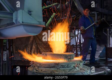 Freiberg, Germania. Giugno 25 2021: Un dipendente del Sächsisches Metallwerk di Friburgo misura la temperatura al forno di fusione con il metallo fuso per la fusione di una campana per la Cattedrale di Merseburg. L'occasione per il lancio della campana è il 1000° anniversario della consacrazione della cattedrale di quest'anno. La campana peserà 890 chilogrammi e suonerà in un unico G. il tono si armonizzerà con le altre campane della cattedrale. Il tono si armonizza con le due grandi campane della chiesa. La campana sarà consacrata il 1° ottobre. Credit: dpa Picture Alliance/Alamy Live News Foto Stock