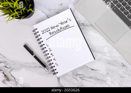 Le risoluzioni di Capodanno 2022 elencano il testo sul blocco note Foto Stock