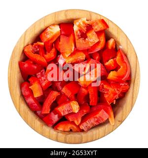 Affettato peperone rosso in una ciotola di legno isolata su sfondo bianco. Verdure fresche e sane. Vista dall'alto. Il file contiene il percorso di ritaglio. Foto Stock