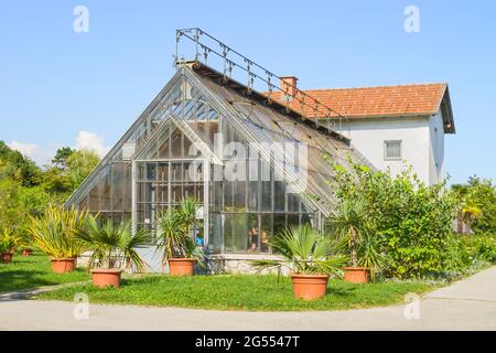 Lubiana, Slovenia - 16 agosto 2018: I visitatori presso l'edificio della serra del parco cittadino di Tivoli in una giornata estiva limpida Foto Stock