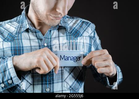 un dipendente maschio che ha un badge con la parola 'magro' sulla sua camicia Foto Stock