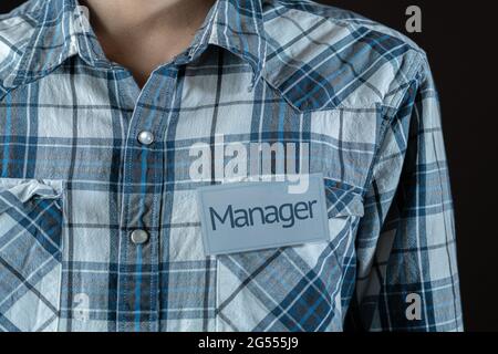 un dipendente maschio che ha un badge con la parola 'magro' sulla sua camicia Foto Stock