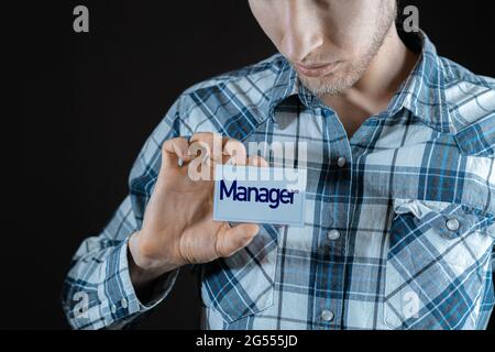 un dipendente maschio che ha un badge con la parola 'magro' sulla sua camicia Foto Stock