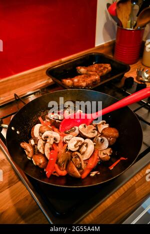 Cucina casalinga mescolare fritto Singapore Noodles con maiale, gamberi, funghi e uova noodle Foto Stock