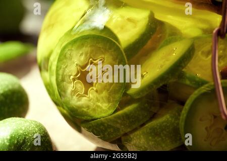 Dettaglio delle noci non mature affettate macerando in alcool in un vaso - preparazione di liquore di noci o tintura fatti in casa Foto Stock