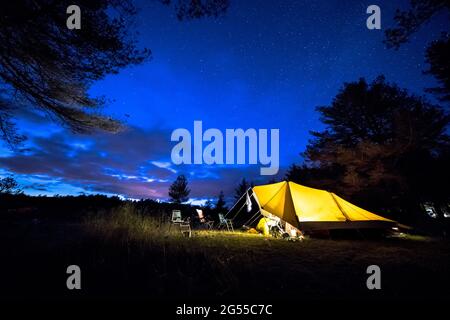 Tenda familiare con acciaio rigido poli su campeggio sotto il cielo stellato con la Via Lattea Foto Stock