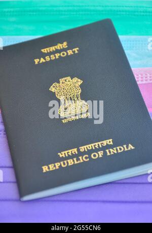 Mandi, Himachal Pradesh, India - 04 24 2021: Primo piano del passaporto indiano su maschera medica multicolore (maschera chirurgica), concetto di viaggio durante la pandemia di Covid19 Foto Stock