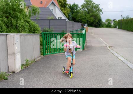 Bambina su uno scooter. Foto Stock