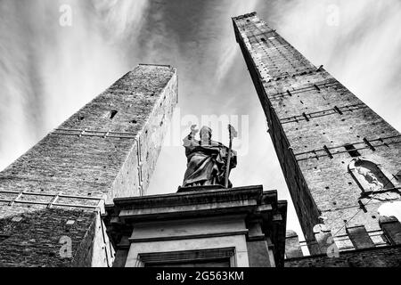 Famose torri medievali di Bologna e la statua di San Petronio. Fotografia urbana in bianco e nero, paesaggio urbano Foto Stock