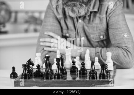 figure di scacchi su tavola di legno. Insegnante di scuola focalizzato. Pensare ad attaccare e catturare pezzi di scacchi avversari. Pensare alla mossa successiva. Uomo bearded Foto Stock