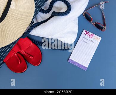 Posato piatto di beachwear con un cappello, scarpe, occhiali da sole e una lista. Foto Stock