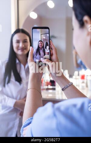 Donna professionista trucco artista fotografare di felice cliente donna con l'applicazione di trucco Foto Stock