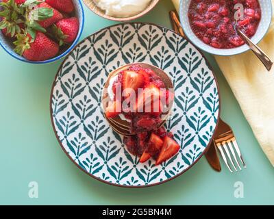 Frittelle di grano saraceno senza glutine di banana, servite con yogurt senza latte e marmellata di fragole di chia Foto Stock