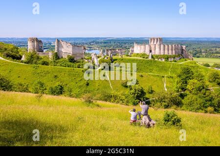 Una coppia più anziana seduta su una groppa guarda le rovine di Château-Gaillard, un castello fortificato costruito in Normandia da Richard il Lionheart. Foto Stock