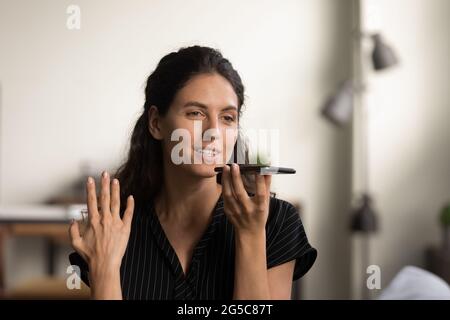 Donna caucasica parla con l'altoparlante sullo smartphone Foto Stock