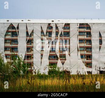 Costruzione di appartamenti imballati in ponteggi e coperture Foto Stock