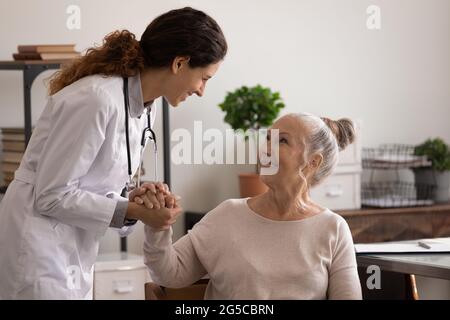 Infermiera sorridente conforto paziente anziano in ospedale Foto Stock