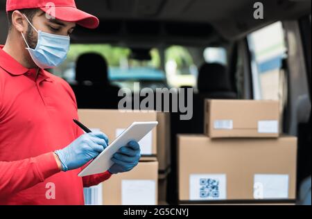 Consegna uomo che indossa maschera protettiva per evitare il virus corona Spread - corriere espresso giovane che lavora durante l'epidemia di coronavirus Foto Stock