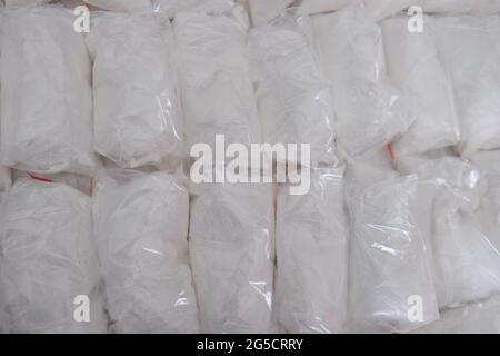 Un gran numero di bustine trasparenti riempite di polvere bianca. Polvere bianca confezionata in bustine piccole. Foto Stock
