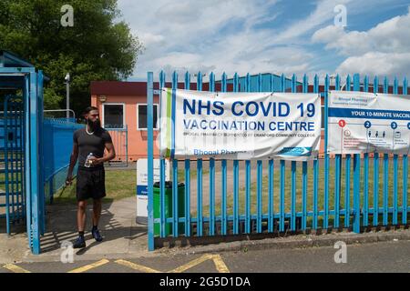 Hounslow, Middlesex, Regno Unito. 26 Giugno 2021. Un uomo lascia il Cranford Community College Covid-19 Vaccination Center a Hounslow. I casi della variante indiana Covid-19 continuano ad essere elevati, tuttavia, i test di sovratensione nella zona sono terminati all'inizio di questa settimana. I tassi di Covid-19 per 100,000 persone per Hounslow al 21 giugno erano 83.6, (227) rispetto al 84.7, (230) la settimana prima. Credit: Maureen McLean/Alamy Live News Foto Stock