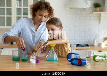 Giovane madre che si prende cura di insegnare la bambina facendo esperimenti di chimica. Foto Stock