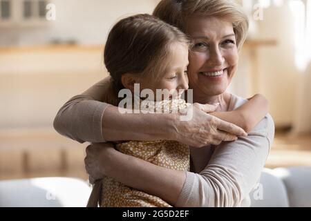 Felice positiva anziana granny coccolante piccola nipote. Foto Stock