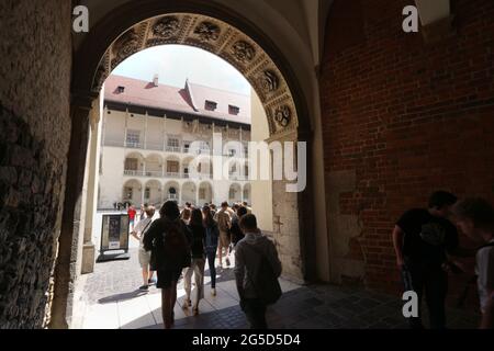 Cracovia. Cracovia. Polonia. Castello reale di Wawel. Gruppo di turisti che entrano nel cortile rinascimentale. Vista dal corridoio. Foto Stock