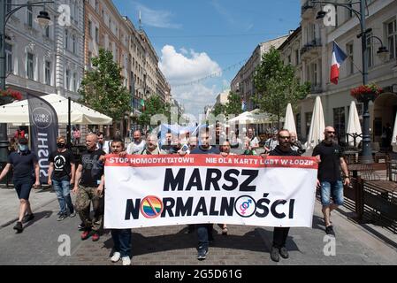 Varsavia, Polonia. 26 Giugno 2021. I membri dei gruppi nazionalisti hanno un banner con la scritta ''normalità marzo'' come contromondimostrazione prima della sfilata di Lodz Pride il 26 giugno 2021 a Lodz, Polonia. Una dozzina di persone provenienti da diversi gruppi nazionalisti hanno marciato attraverso la città in una contromondimostrazione chiamata ''marcia normalità'' per opporsi alla parata Pride che si svolge lo stesso giorno a Lodz. Credit: Aleksander Kalka/ZUMA Wire/Alamy Live News Foto Stock