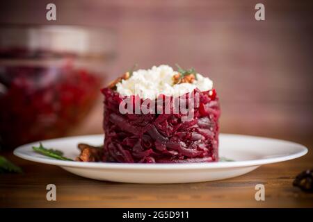 insalata dietetica di barbabietole bollite con noci e formaggio di cottage su un tavolo di legno Foto Stock