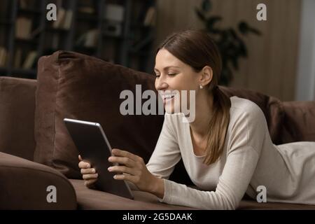 Giovane donna allegra che usa un tablet per computer digitale. Foto Stock